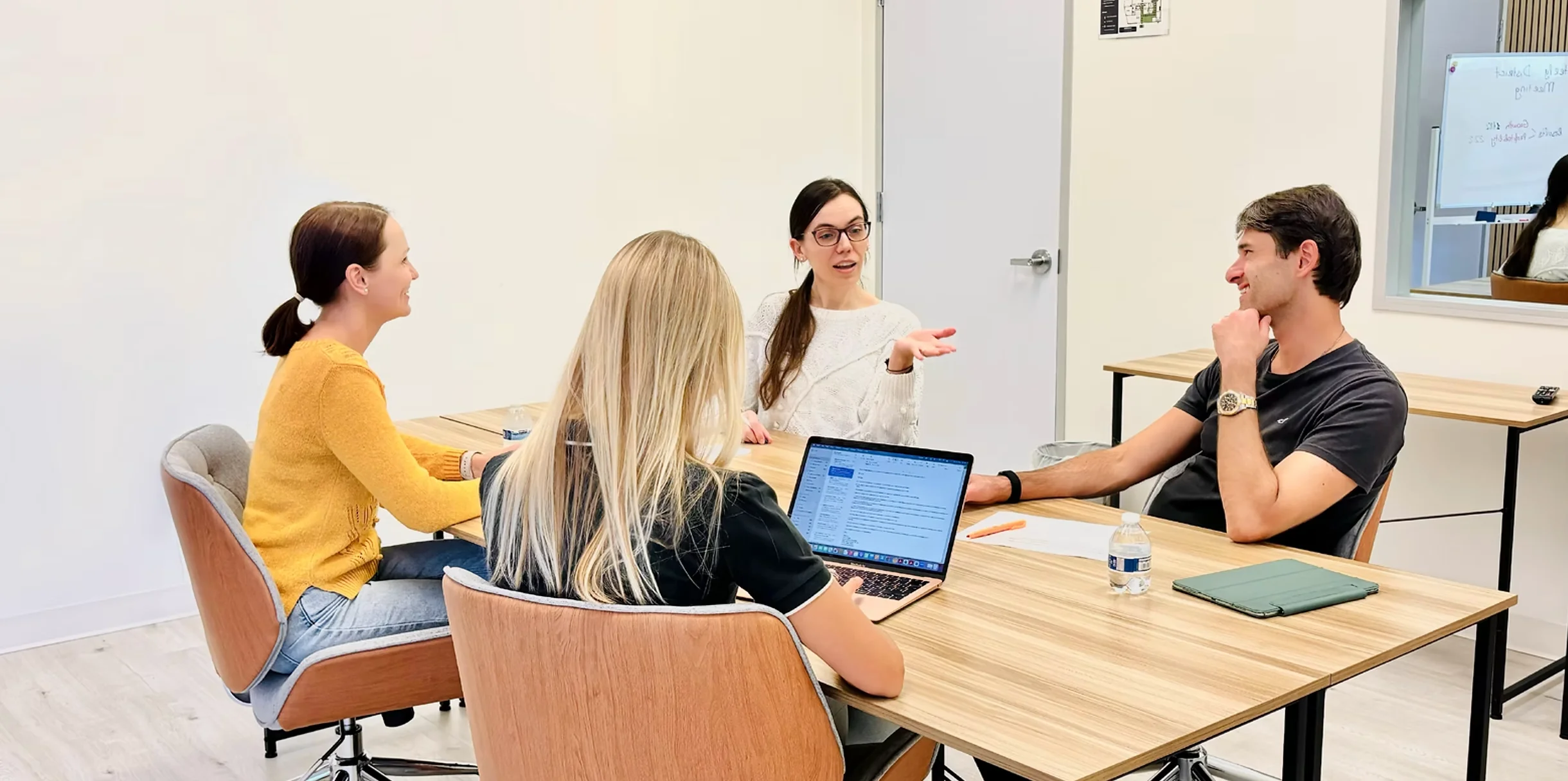 WorkCastle coworking space with four professionals collaborating around a wooden meeting table