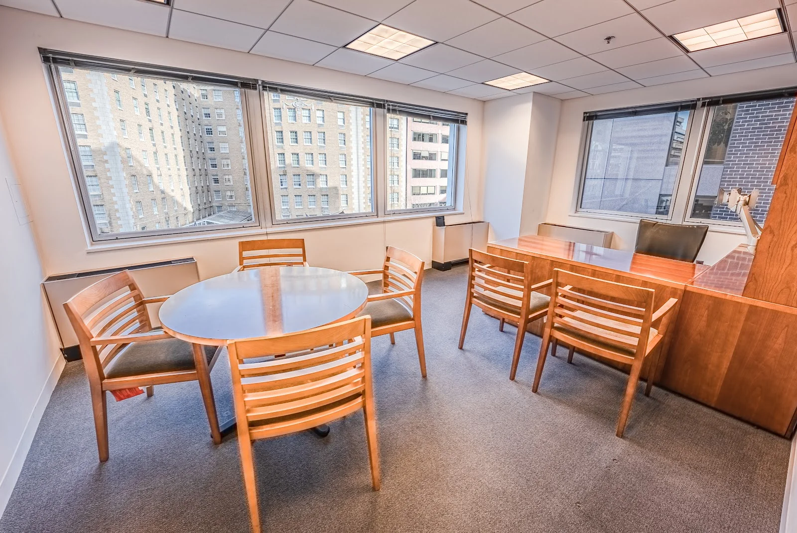LocalWorks Connecticut Ave traditional meeting room with round wooden table, chairs, and city building views through large windows